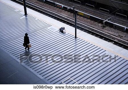 Stock Photography - Commuter standing on a platform. Fotosearch