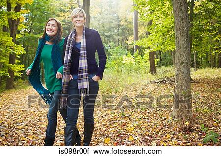 Stock Image - Friends walking in forest. Fotosearch