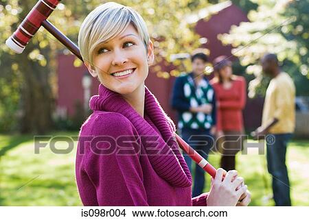 Picture - Young woman with croquet mallet. Fotosearch