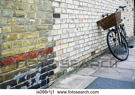 A bicycle leaning against a wall View Large Photo Image Stock Image - A bicycle leaning against a wall. Fotosearch