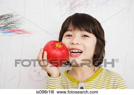 A boy holding an apple View Large Photo Image Stock Photograph - A boy holding an apple. Fotosearch