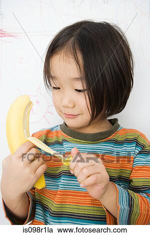 Stock Image - A boy peeling a banana. Fotosearch
