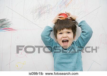 A boy with an apple on his head View Large Photo Image Stock Image - A boy with an apple on his head. Fotosearch