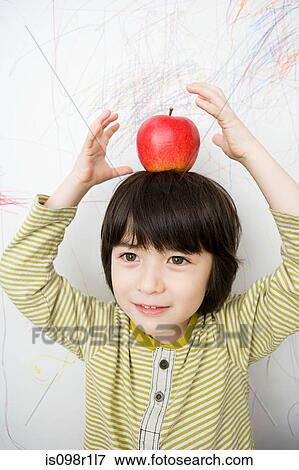 A boy with an apple on his head View Large Photo Image Stock Photo - A boy with an apple on his head. Fotosearch
