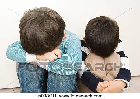 Stock Image - Boys covering their faces. Fotosearch
