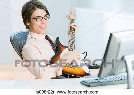 Man with guitar in office View Large Photo Image Stock Photography - Man with guitar in office. Fotosearch