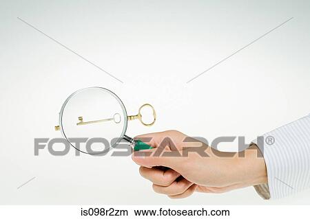 Person magnifying key View Large Photo Image Picture - Person magnifying key. Fotosearch