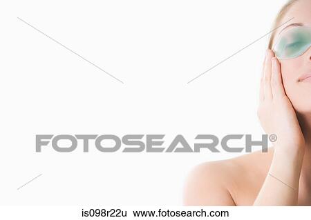 Stock Photograph - Woman using eye mask. Fotosearch