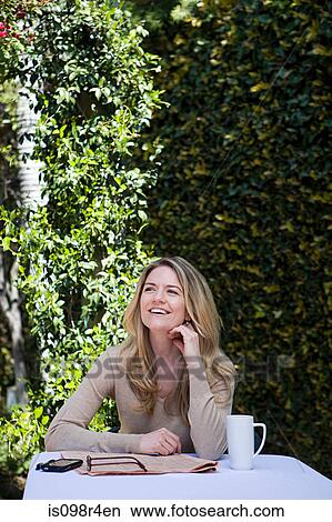 Woman at table outdoors View Large Photo Image Picture - Woman at table outdoors. Fotosearch