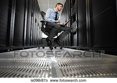 Picture - Computer technician working on a server. Fotosearch