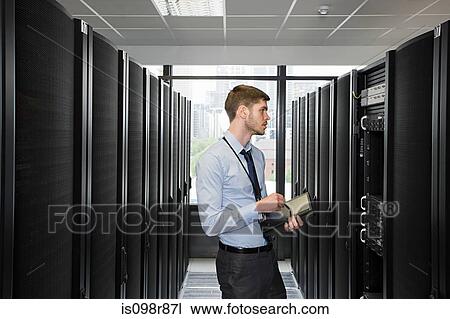 Computer technician working on a server View Large Photo Image Stock Image - Computer technician working on a server. Fotosearch