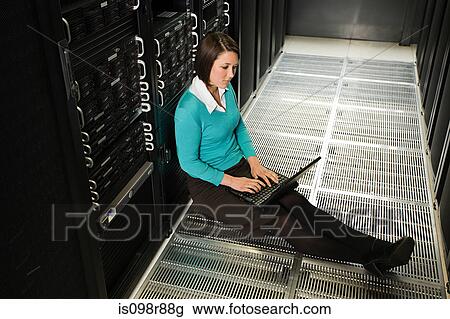 Stock Image - Female computer technician sitting on the floor. Fotosearch