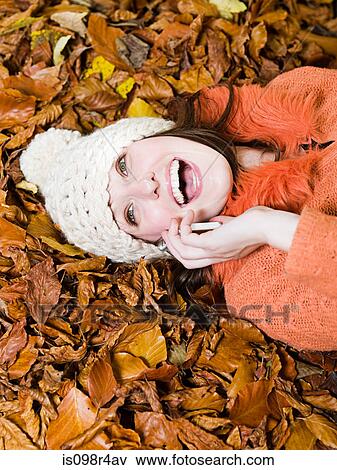 Smiling woman on autumn leaves View Large Photo Image Stock Photo - Smiling woman on autumn leaves. Fotosearch