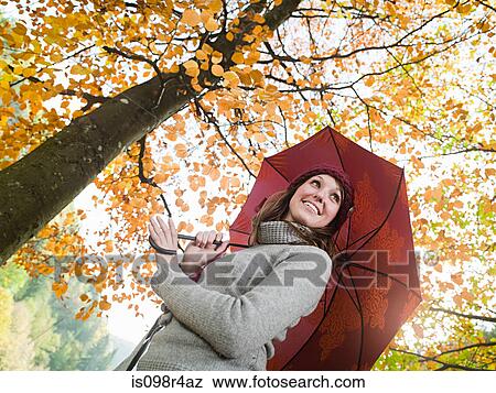 Woman holding an umbrella in a forest View Large Photo Image Stock Photo - Woman holding an umbrella in a forest. Fotosearch