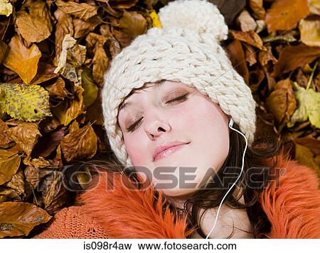 Woman relaxing on the autumn leaves View Large Photo Image Stock Photo - Woman relaxing on the autumn leaves. Fotosearch