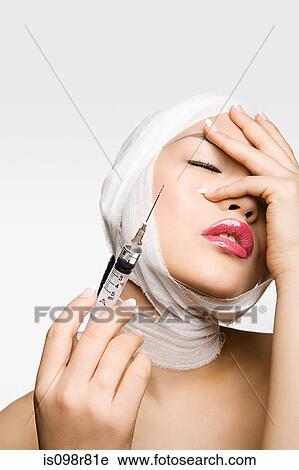 Stock Image - Young woman having cosmetic surgery. Fotosearch