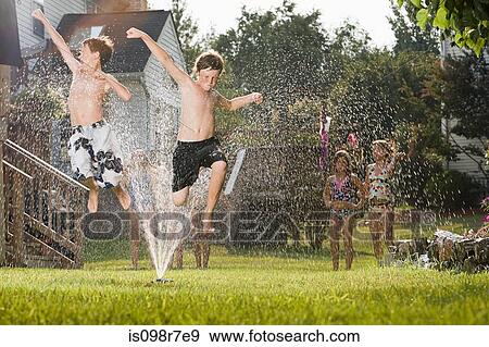 Children jumping in sprinkler View Large Photo Image Stock Photo - Children jumping in sprinkler. Fotosearch