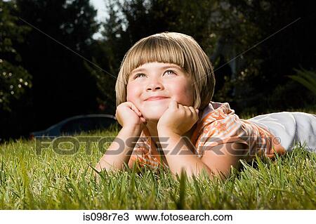 Girl lying on grass View Large Photo Image Stock Image - Girl lying on grass. Fotosearch