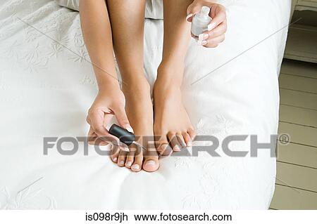 Stock Image - Woman painting toenails. Fotosearch