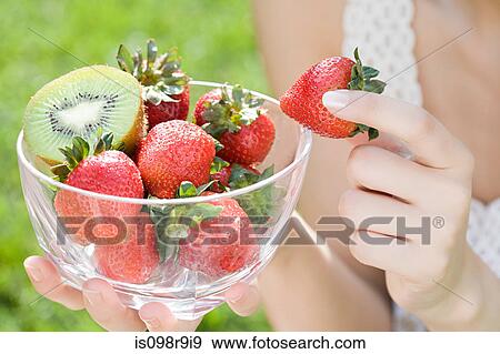 Woman with bowl of strawberries and kiwi View Large Photo Image Stock Photo - Woman with bowl of strawberries and kiwi. Fotosearch