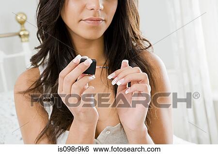 Young woman painting fingernails View Large Photo Image Stock Photograph - Young woman painting fingernails. Fotosearch