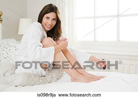 Young woman painting toenails View Large Photo Image Stock Image - Young woman painting toenails. Fotosearch