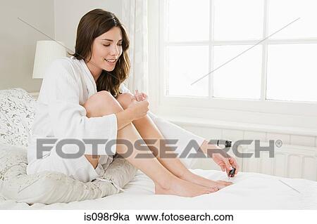 Young woman painting toenails View Large Photo Image Stock Image - Young woman painting toenails. Fotosearch