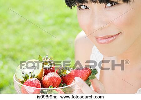 Young woman with bowl of fruit View Large Photo Image Stock Image - Young woman with bowl of fruit. Fotosearch