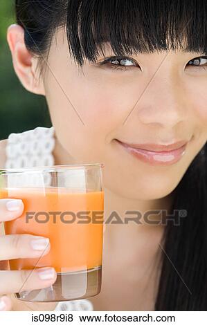 Young woman with glass of juice View Large Photo Image Stock Photo - Young woman with glass of juice. Fotosearch