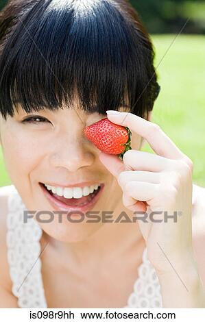 Stock Image - Young woman with strawberry. Fotosearch