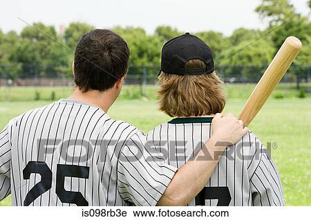 Stock Image - Father and son on baseball field. Fotosearch