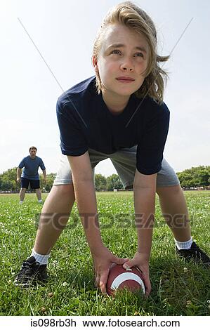 Stock Image - Father and son playing american football. Fotosearch