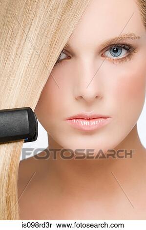 Young woman using straightening irons View Large Photo Image Stock Photography - Young woman using straightening irons. Fotosearch