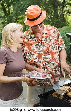 Couple having a barbecue View Large Photo Image Stock Photo - Couple having a barbecue. Fotosearch