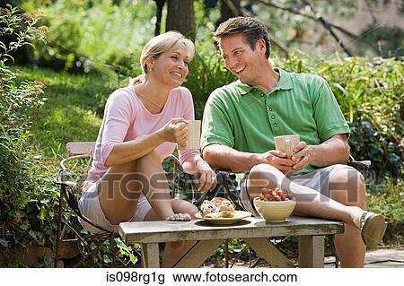 Couple having drink in garden View Large Photo Image Stock Image - Couple having drink in garden. Fotosearch