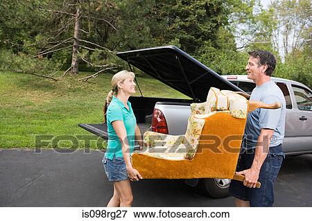Couple moving armchair View Large Photo Image Stock Photo - Couple moving armchair. Fotosearch