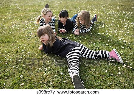 Four girls lying on grass View Large Photo Image Stock Photo - Four girls lying on grass. Fotosearch