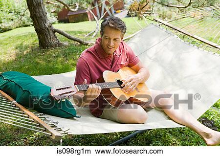 Man playing guitar outdoors View Large Photo Image Picture - Man playing guitar outdoors. Fotosearch