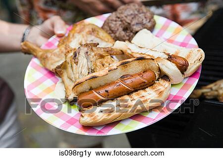 Stock Photo - Person holding plate of barbecue food. Fotosearch