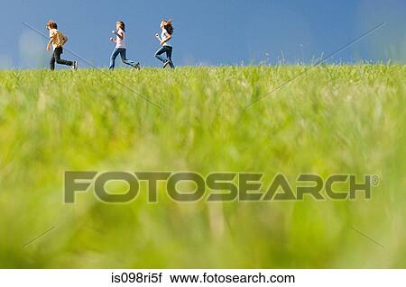 Stock Image - Children running in field. Fotosearch