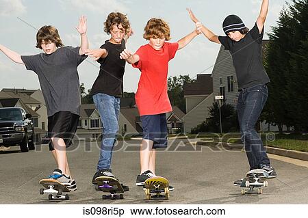 Stock Photography - Four boys skateboarding. Fotosearch