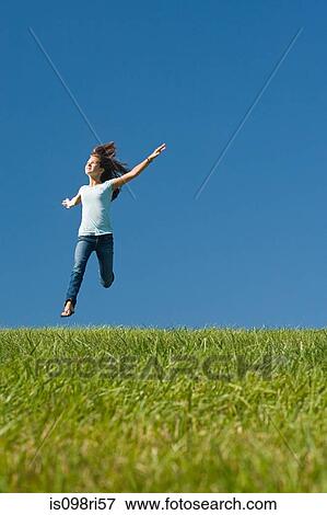Stock Photo - Girl jumping in a field. Fotosearch
