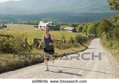 Mature adult man running on rural road View Large Photo Image Stock Image - Mature adult man running on rural road. Fotosearch