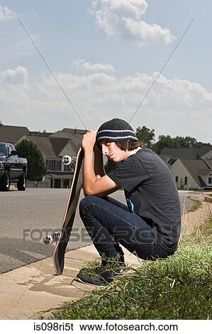 Stock Photograph - Teenage boy with a skateboard. Fotosearch