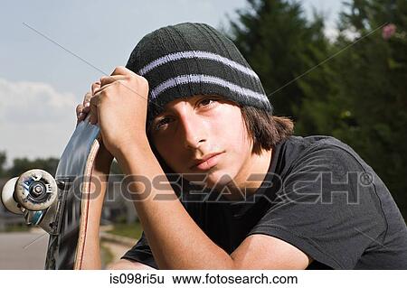 Teenage boy with a skateboard View Large Photo Image Stock Photograph - Teenage boy with a skateboard. Fotosearch