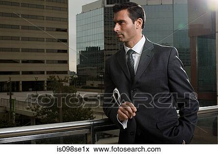 A businessman leaning on a hand rail View Large Photo Image Stock Photo - A businessman leaning on a hand rail. Fotosearch