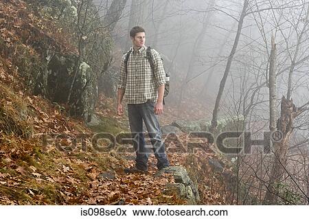 A male hiker explores a misty forest View Large Photo Image Stock Photo - A male hiker explores a misty forest. Fotosearch