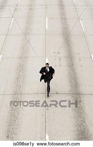 Looking down to a businessman running down a road View Large Photo Image Stock Photo - Looking down to a businessman running down a road. Fotosearch
