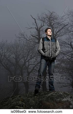 Portrait of a male hiker standing on a forest boulder View Large Photo Image Stock Image - Portrait of a male hiker standing on a forest boulder. Fotosearch