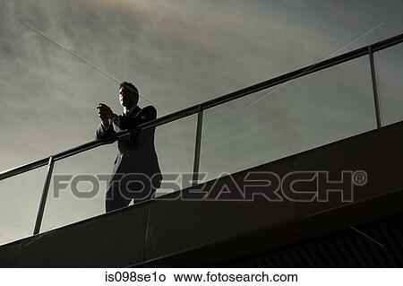 Silhouette of a businessman on a bridge View Large Photo Image Picture - Silhouette of a businessman on a bridge. Fotosearch